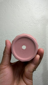 Underside of the pink ceramic cactus pot showing the center drainage hole