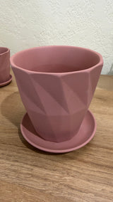 Two faceted pink ceramic cactus pots with saucers shown together for size comparison