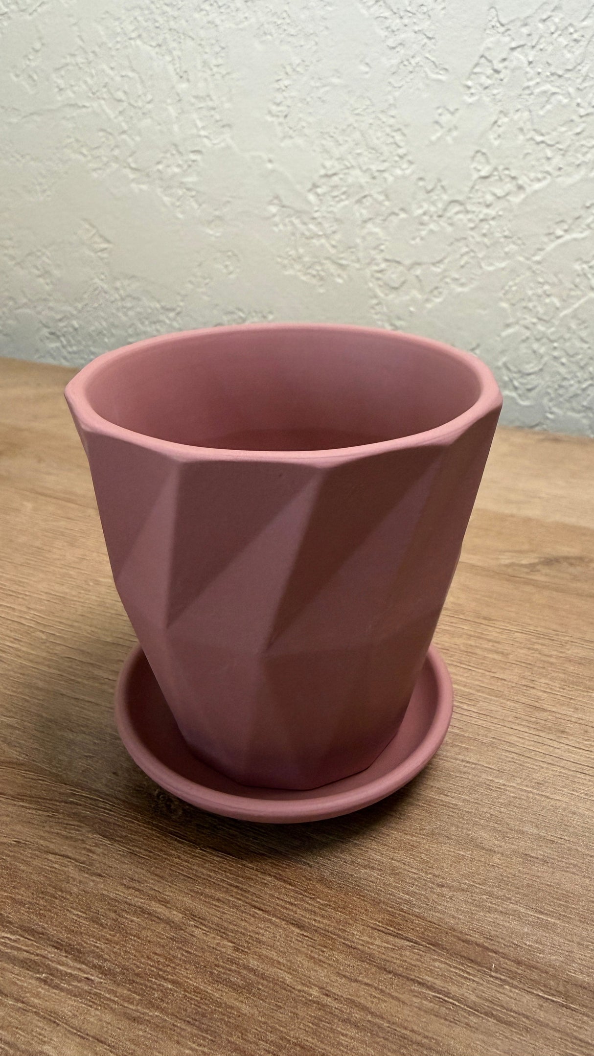 Pink ceramic planter seen from above showing the smooth interior and matching saucer
